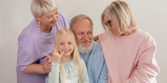A joyful multigenerational family poses and smiles together indoors, showcasing love and togetherness.