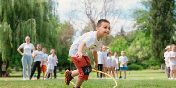 Kids enjoy outdoor fun with hula hoops in a vibrant park setting.